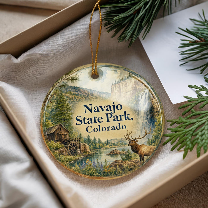 A decorative ornament with a scenic landscape of Navajo State Park, Colorado, featuring a deer, a watermill, and a forest.