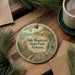 A round ornament with a scenic illustration of Oak Mountain State Park, Alabama, hanging on a wooden surface.
