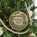 A round ornament hanging on a Christmas tree, featuring a scenic image of Oak Mountain State Park, Alabama.