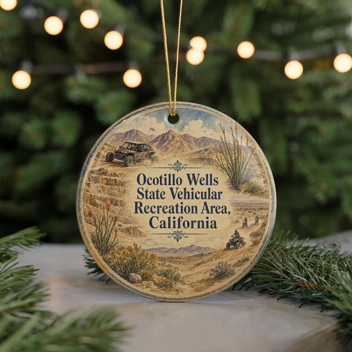 A round ornament with a desert landscape and a vehicle, hanging on a string.