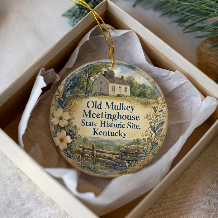 A decorative ornament in a box, featuring a house and a tree, with the text "Old Mulkey Meetinghouse State Historic Site, Kentucky" printed on it.