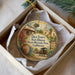 A decorative ornament in a box, featuring a painting of a historical building and a wagon, with the text "Old Town San Diego State Historic Park, California" and "Fiesta de ReYES" written on it.