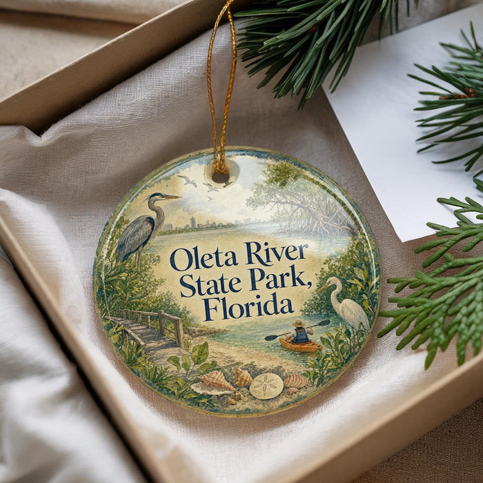 A decorative ornament with a scenic image of the Oleta River State Park in Florida, featuring a bird, a boat, and a person kayaking.
