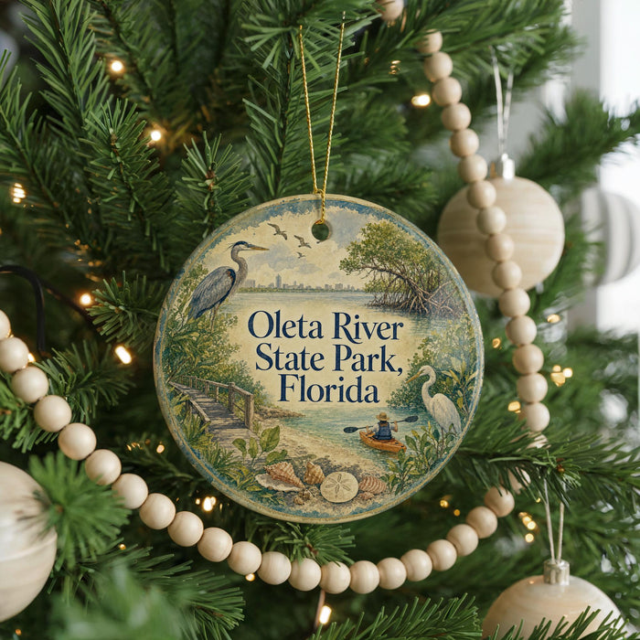 A round ornament hanging on a Christmas tree, featuring illustrations of a bird, a boat, and a beach scene, with the text "Ota River State Park, Florida" displayed prominently.