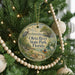 A round ornament hanging on a Christmas tree, featuring illustrations of a bird, a boat, and a beach scene, with the text "Ota River State Park, Florida" displayed prominently.