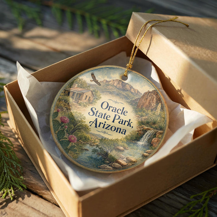 A decorative ornament in a box, featuring a scenic landscape with mountains, a waterfall, and a small cabin.