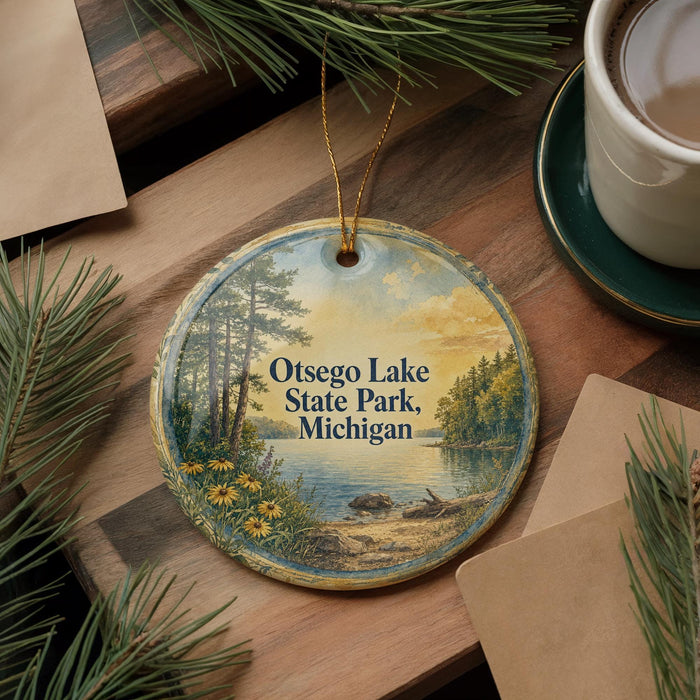 A decorative ornament featuring a scenic landscape of Otsego Lake State Park, Michigan, with pine trees and a lake in the background.
