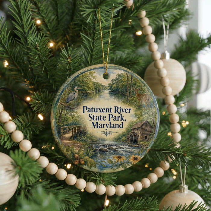 A round ornament hanging on a Christmas tree, featuring a scenic image of Patuxent River State Park, Maryland.