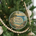 A round ornament hanging on a Christmas tree, featuring a scenic image of Petoskey State Park, Michigan.