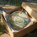 A round ornament in a box, featuring a scenic image of Petoskey State Park, Michigan.