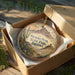 A decorative ornament in a wooden box, featuring a desert landscape with mountains and cacti, with the text "PICACHO PEAK STATE PARK ARIZONA" printed on it.