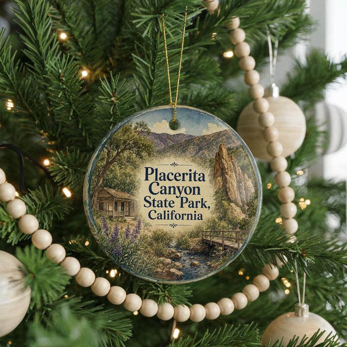 A round ornament hanging on a Christmas tree, featuring a scenic image of Placerita Canyon State Park, California.