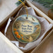 A round ornament with a scenic image of Point Mugu State Park, California, hanging from a string.