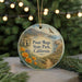 A round ornament with a scenic landscape of Point Mugu State Park, California, featuring a winding path, mountains, and a bird in flight.