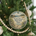 A round ornament hanging on a Christmas tree, featuring a scenic image of Popham Beach State Park in Maine.