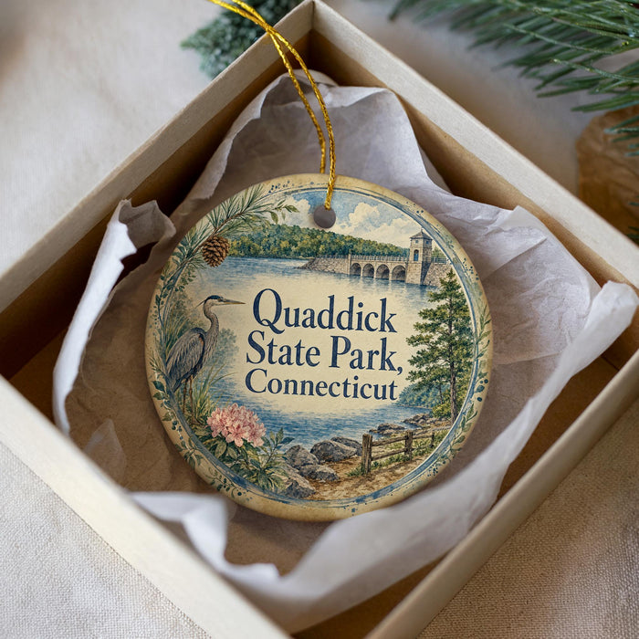 A decorative ornament in a box, featuring a scenic image of Quaddick State Park in Connecticut.