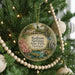 A round ornament hanging on a Christmas tree, featuring a scenic image of Radium Springs State Park in Georgia.