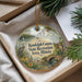 An ornament in a box, featuring a scenic landscape with a lake, bridge, and wildlife, including a crane and a heron.