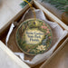 An ornament in a white box, featuring a circular design with a lush garden scene and the text "Ravine Gardens State Park, Florida".