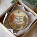 A round ornament with a scenic illustration of the Red Rock Canyon State Park in California, hanging from a string.