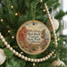 A round ornament hanging on a Christmas tree, featuring a scenic image of the Red Rock Canyon State Park in California.