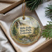 A decorative ornament with a scenic image of a waterfall and forest, hanging from a string.