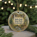 A round ornament with a scenic image of a waterfall and forest, hanging from a string.