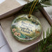 A decorative ornament in a box, featuring a scene from River Rise Preserve State Park, Florida, with a deer and other wildlife elements.