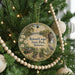 A round ornament hanging on a Christmas tree, featuring a scenic image of Roland Cooper State Park in Alabama.