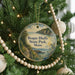 A Christmas tree decorated with ornaments, including a circular ornament with a scenic image of Rogue Bluffs State Park, Maine.
