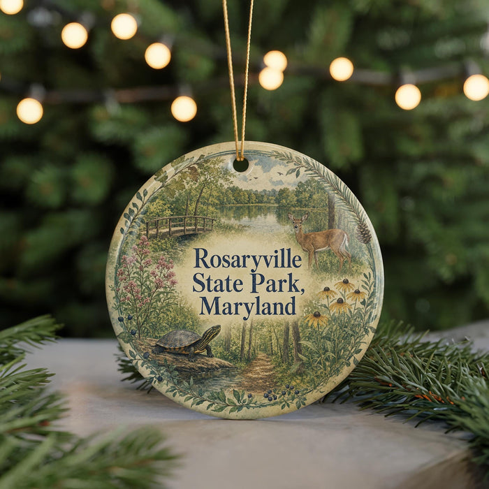 A round ornament with a scenic image of Rosaryville State Park, Maryland, featuring a turtle, deer, and flowers, surrounded by greenery and a string of lights.
