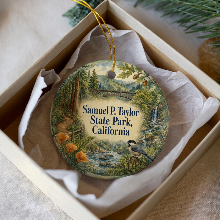 A decorative ornament in a white box, featuring a scenic landscape with a bird, trees, and a river.