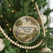 A round ornament hanging on a Christmas tree, featuring a scenic image of a bird and palm trees, with the text "Savannas Preserve State Park, Florida" displayed on it.