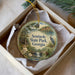 A decorative ornament in a box, featuring a scenic landscape with a lake, trees, and a bird, along with the text "Seminole State Park, Georgia".