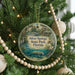 A round ornament hanging on a Christmas tree, featuring a scenic image of Silver Springs State Park in Florida.