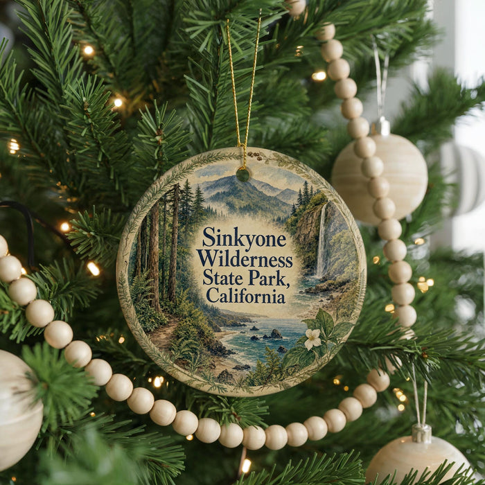 A round ornament hanging on a Christmas tree, featuring a scenic image of Sinkone Wilderness State Park, California.