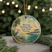 A circular ornament featuring a serene scene of a bird standing on a rock near a pier, with palm trees and a sunset in the background.