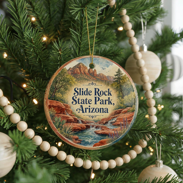 A round ornament hanging on a Christmas tree, featuring a scenic image of Slide Rock State Park in Arizona.