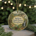 A round ornament with a scenic forest landscape and a sign reading "Spenser State Forest, Massachusetts" hangs in front of a blurred Christmas tree with lights.