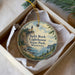 A decorative ornament in a box, featuring a lighthouse and a scenic landscape.