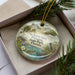 A decorative ornament in a box, featuring illustrations of St. Lucie Inlet, St. Lucie Park, and a bird, with the text "St. Lucie Inlet Preserve State Park, Florida" printed on it.