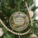 A round ornament hanging on a Christmas tree, featuring a scenic image of State Forest State Park, Colorado.