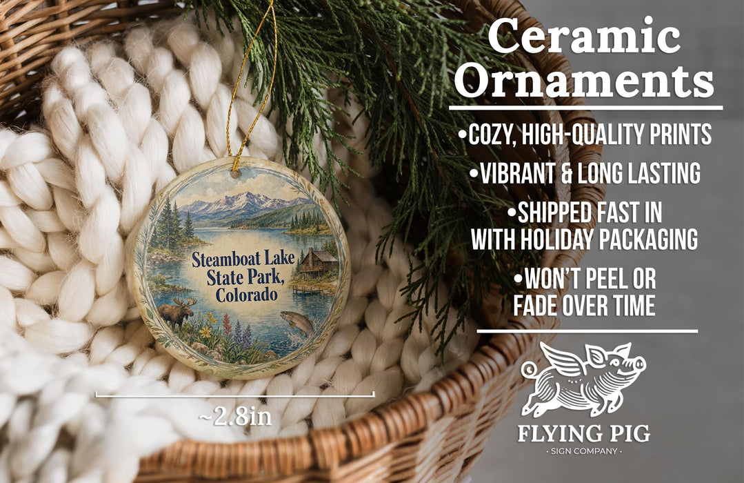 Ceramic ornaments, specifically Steamboat Lake State Park, Colorado ornaments, are displayed in a basket with pine branches. The text highlights the ornaments as "Cozy, High-quality prints, Vibrant & long lasting, Shipped fast in with holiday packaging, Won't peel or fade over time".