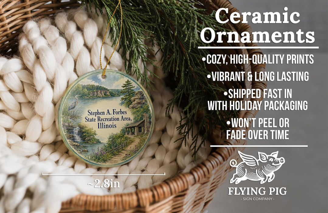 Ceramic ornaments, featuring a scenic landscape of Stephen A. Forbes State Recreation Area, Illinois, are displayed in a wicker basket. The ornaments are described as cozy, high-quality prints with vibrant and long-lasting vibrancy, and are shipped fast in holiday packaging, with the exception of the pig ornaments, which are not described.