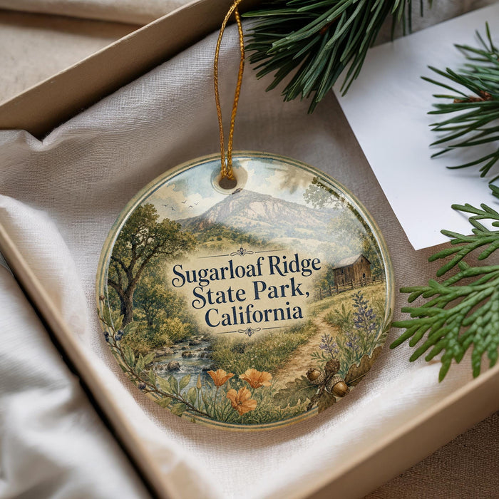 A decorative ornament with a scenic landscape of Sugarloaf Ridge State Park, California, featuring a mountain, trees, and a stream.