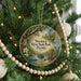 A circular ornament hanging on a Christmas tree, featuring a scenic image of Suwannee River State Park, Florida.