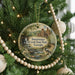 A round ornament hanging on a Christmas tree, featuring a scenic image of Sweetwater Creek State Park in Georgia.