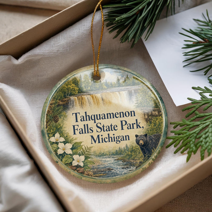 A decorative ornament with a waterfall and flowers, featuring the text "Tahquamenon Falls State Park, Michigan" and a black bear image.