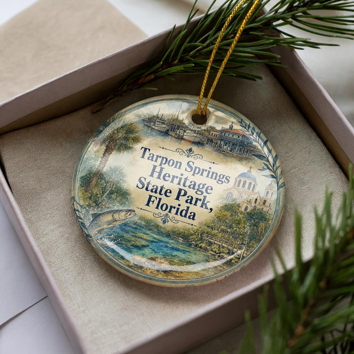A decorative ornament in a box, featuring a scenic image of Tarpon Springs Heritage State Park, Florida.