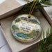 A decorative ornament in a box, featuring a scenic image of Tarpon Springs Heritage State Park, Florida.